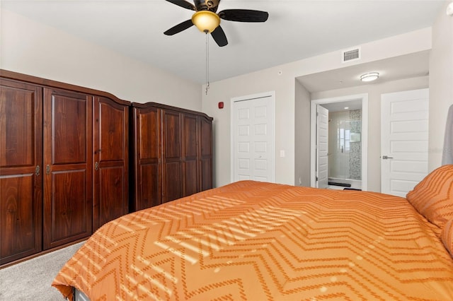 carpeted bedroom with visible vents, ceiling fan, and ensuite bath