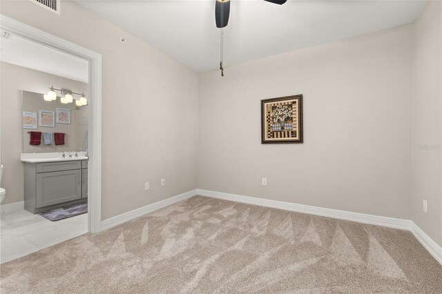 spare room with light carpet, visible vents, and baseboards