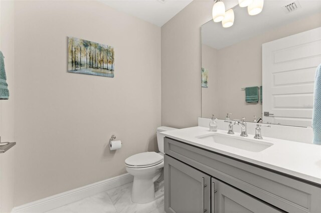 bathroom featuring marble finish floor, visible vents, toilet, vanity, and baseboards