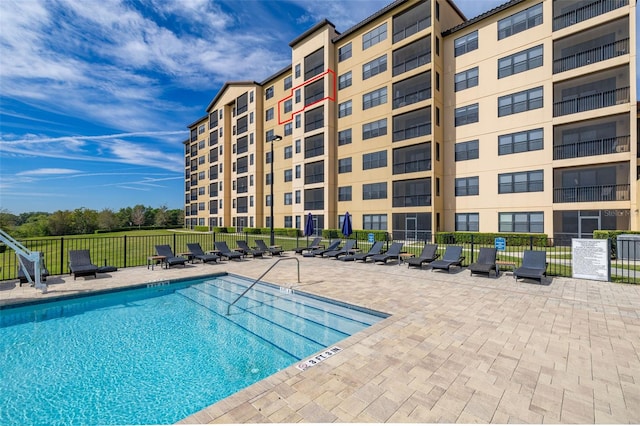 view of pool with a patio area and fence