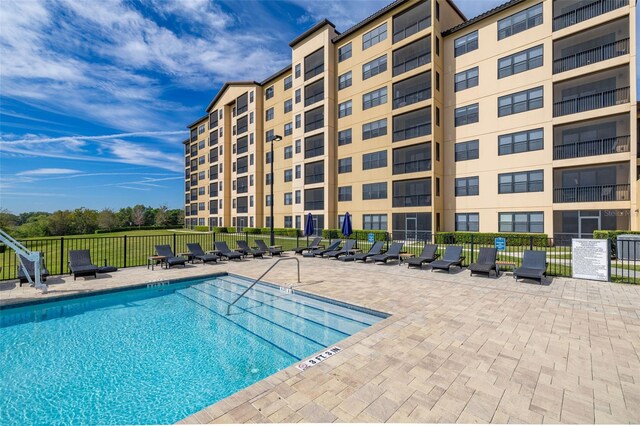 view of pool with a patio area and fence