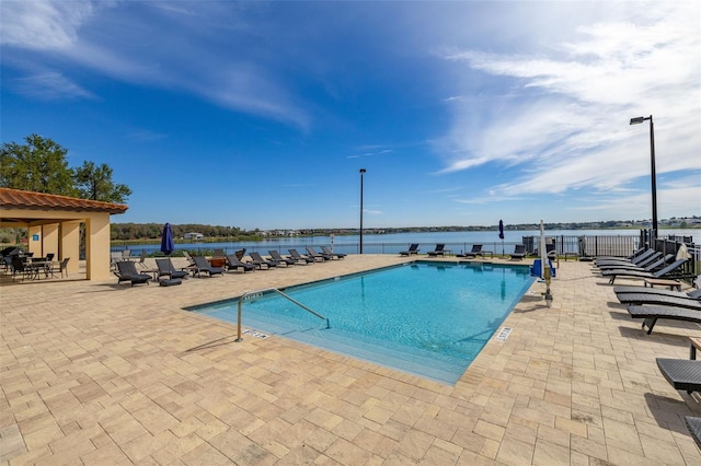 pool featuring a water view and a patio