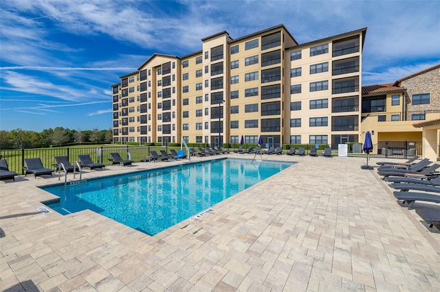 community pool featuring fence and a patio