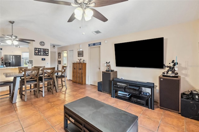 living area with lofted ceiling, light tile patterned floors, visible vents, and a ceiling fan