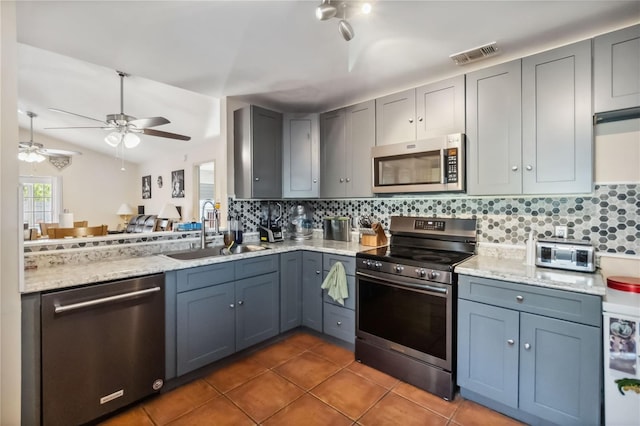 kitchen featuring dark tile patterned flooring, a sink, visible vents, appliances with stainless steel finishes, and tasteful backsplash