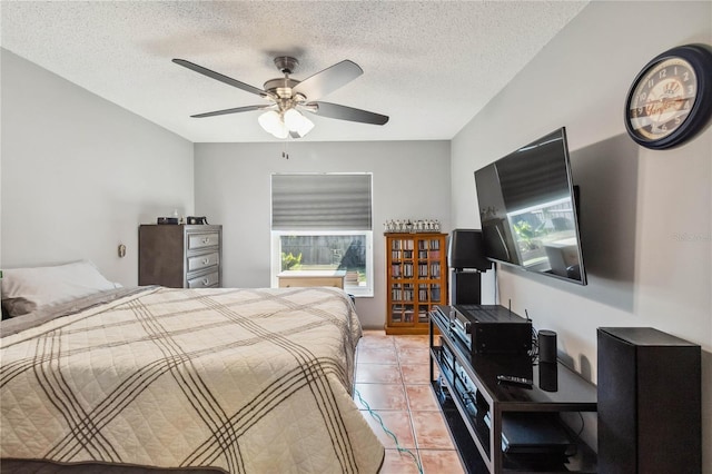 bedroom with light tile patterned floors, ceiling fan, and a textured ceiling