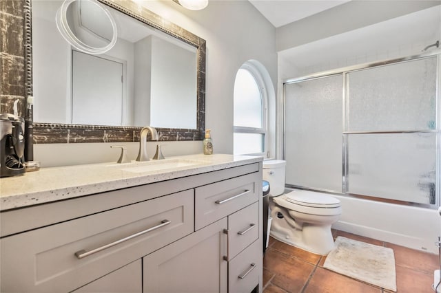 full bathroom with toilet, tile patterned floors, combined bath / shower with glass door, and vanity