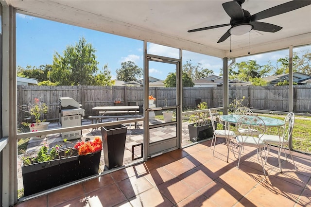 sunroom / solarium featuring plenty of natural light and ceiling fan