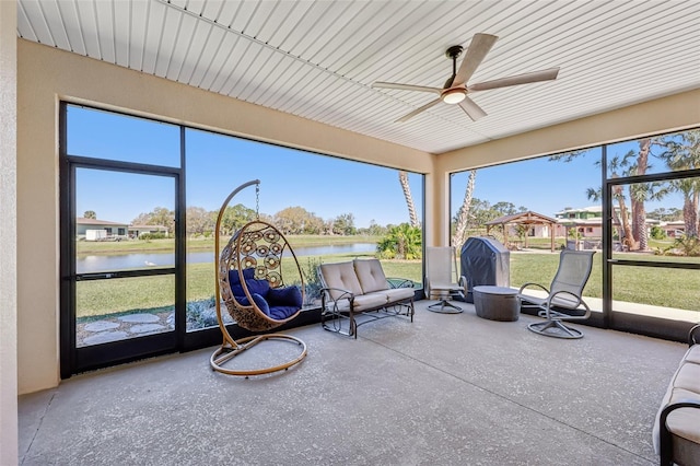 sunroom with a water view and a ceiling fan