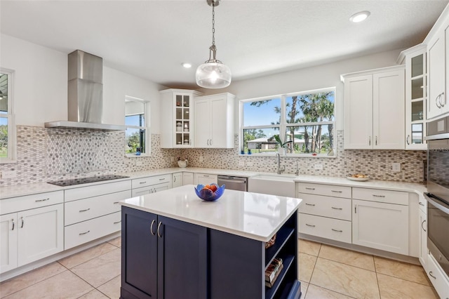 kitchen featuring white cabinets, light countertops, wall chimney exhaust hood, and black electric cooktop