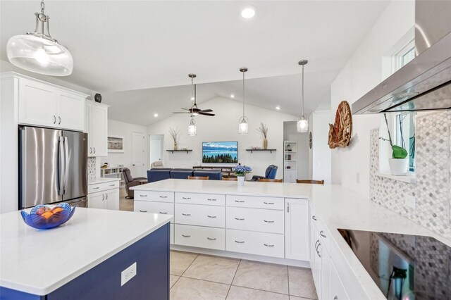 kitchen with a peninsula, open floor plan, light countertops, and freestanding refrigerator