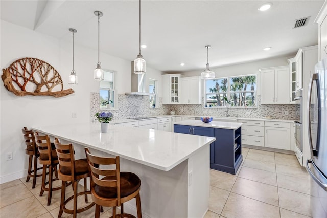 kitchen featuring a peninsula, blue cabinetry, white cabinetry, and black electric cooktop