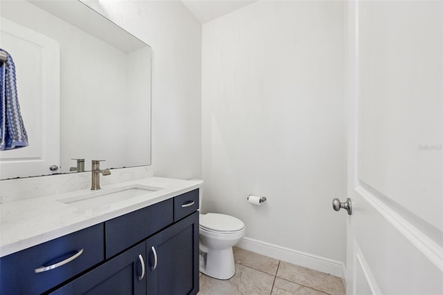 bathroom with toilet, tile patterned flooring, vanity, and baseboards