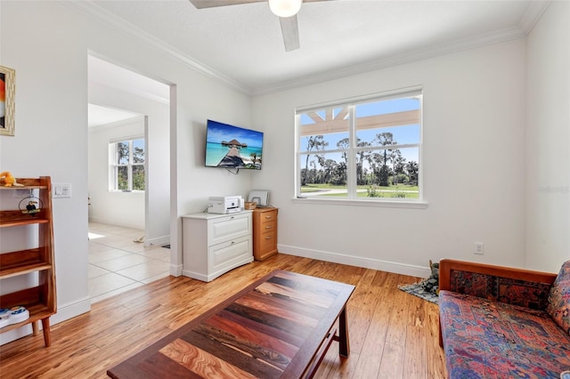 sitting room with light wood-style flooring, ornamental molding, and a wealth of natural light