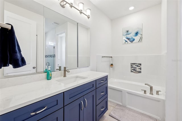 bathroom featuring vanity and a bath