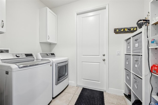 clothes washing area with cabinet space, separate washer and dryer, and light tile patterned flooring