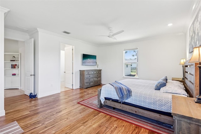 bedroom with light wood finished floors, baseboards, visible vents, ceiling fan, and ornamental molding