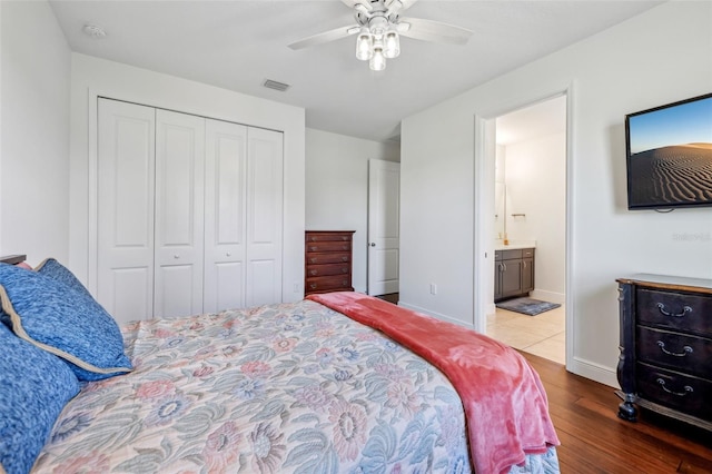 bedroom featuring a closet, visible vents, a ceiling fan, wood finished floors, and baseboards