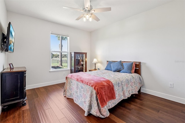 bedroom featuring ceiling fan, wood finished floors, and baseboards