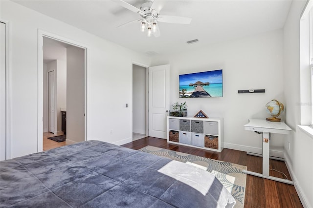 bedroom with a ceiling fan, baseboards, visible vents, and wood finished floors