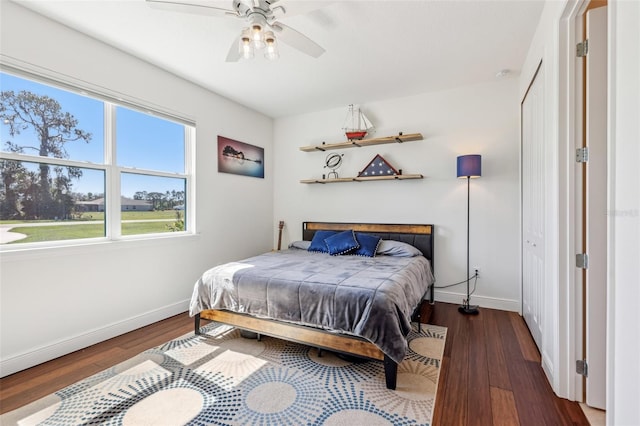 bedroom featuring a ceiling fan, baseboards, and wood finished floors