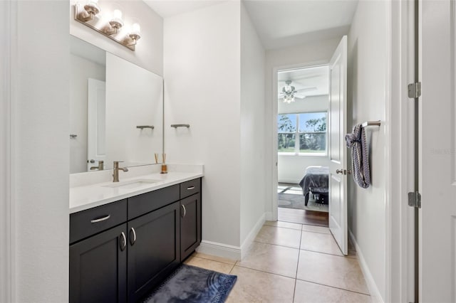 ensuite bathroom featuring connected bathroom, tile patterned flooring, vanity, and baseboards