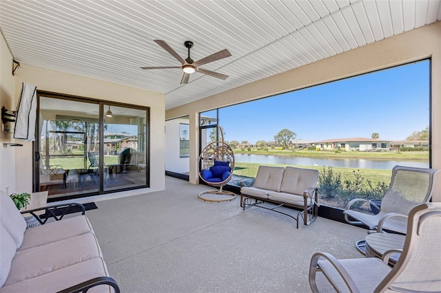 sunroom / solarium with a water view and a ceiling fan