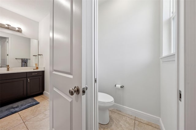 bathroom with baseboards, vanity, toilet, and tile patterned floors