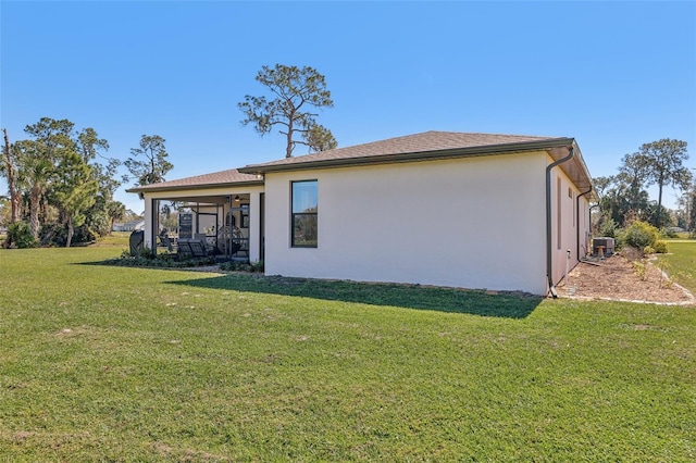 rear view of property with a yard and stucco siding