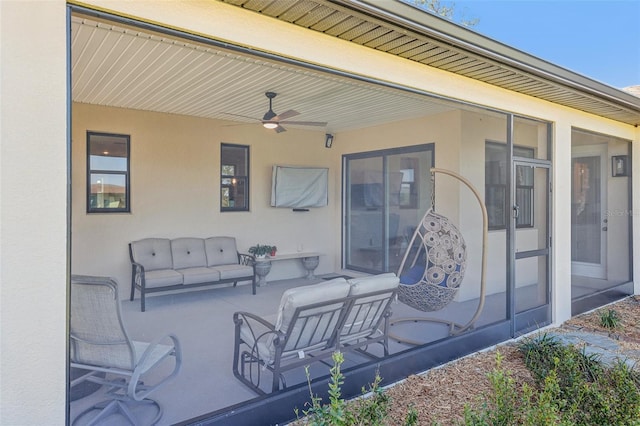 view of patio / terrace with a sunroom, an outdoor living space, and a ceiling fan