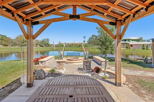 view of patio featuring an outdoor fire pit and a water view