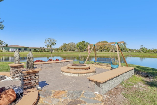 view of patio with an outdoor fire pit and a water view