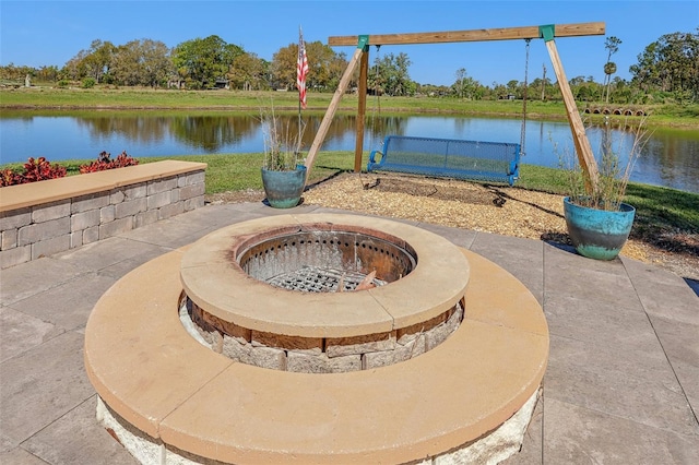 view of patio with a water view and a fire pit