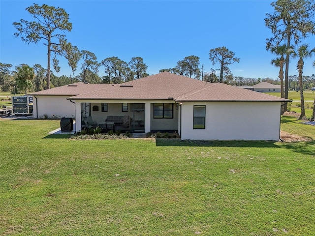 rear view of property with a lawn and stucco siding