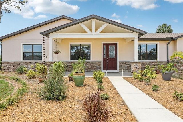 3607 Hidden River Ln, Tavares, FL 32778 - view of front of house with stucco siding, stone siding, and a porch