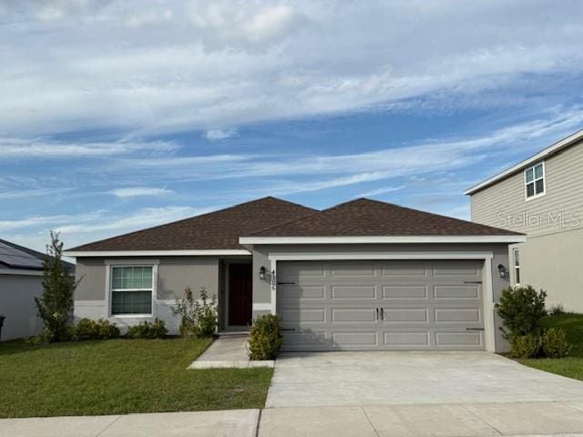 ranch-style home featuring a shingled roof, a front yard, stucco siding, driveway, and an attached garage