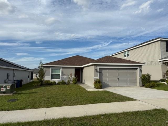 ranch-style home with stucco siding, an attached garage, concrete driveway, and a front yard