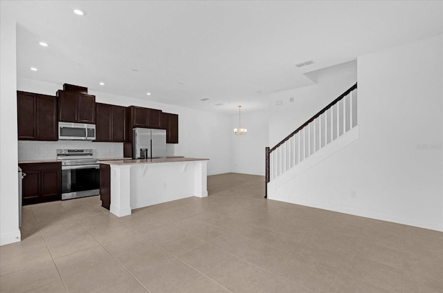 kitchen with recessed lighting, stainless steel appliances, visible vents, a center island, and a kitchen bar