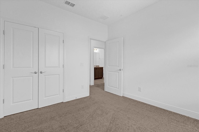 unfurnished bedroom with a closet, carpet flooring, visible vents, and baseboards