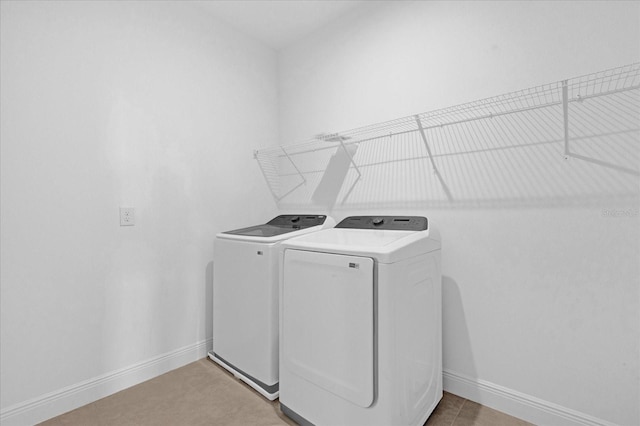 laundry area with baseboards, laundry area, and washer and dryer