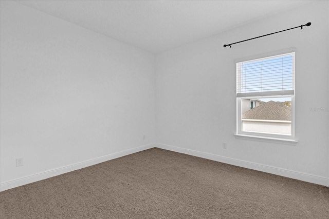 carpeted spare room featuring baseboards