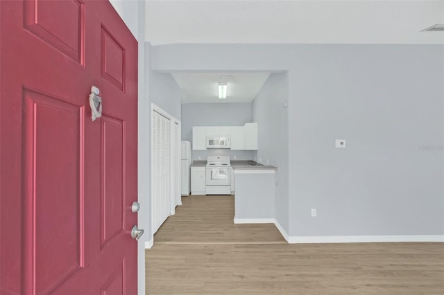 entryway featuring light wood-type flooring, visible vents, and baseboards