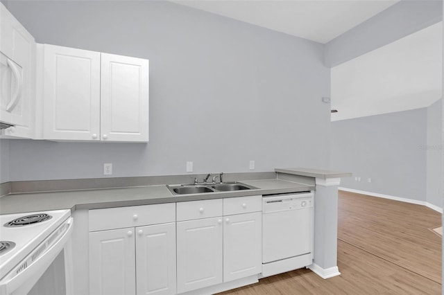 kitchen with white appliances, white cabinetry, light wood-style floors, and a sink