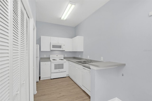 kitchen with light countertops, white cabinetry, a sink, light wood-type flooring, and white appliances