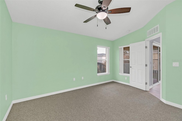 unfurnished room with carpet floors, visible vents, baseboards, and a ceiling fan