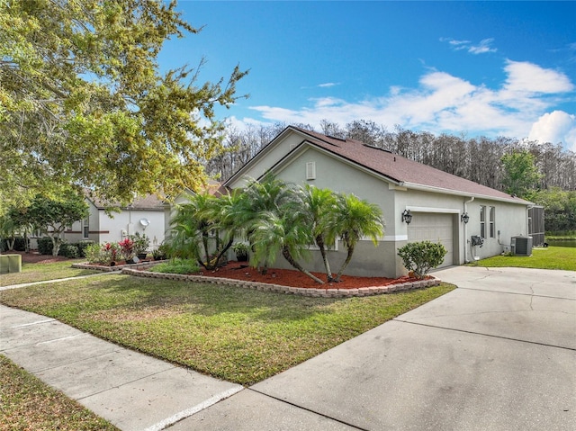 single story home with stucco siding, a front lawn, concrete driveway, an attached garage, and central AC unit