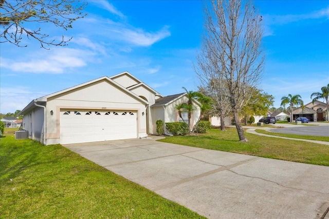 single story home featuring a garage, driveway, a front lawn, and stucco siding