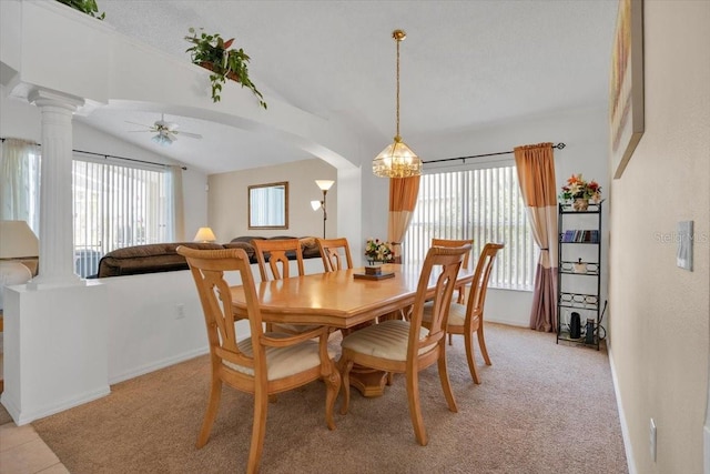 dining space featuring lofted ceiling, plenty of natural light, arched walkways, and decorative columns