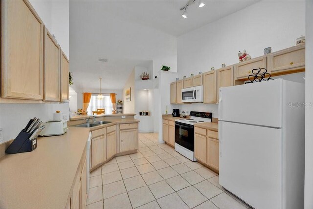 kitchen with light tile patterned floors, light brown cabinets, white appliances, a sink, and light countertops