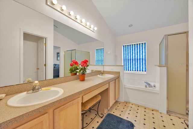 full bath with vaulted ceiling, double vanity, a sink, and a garden tub